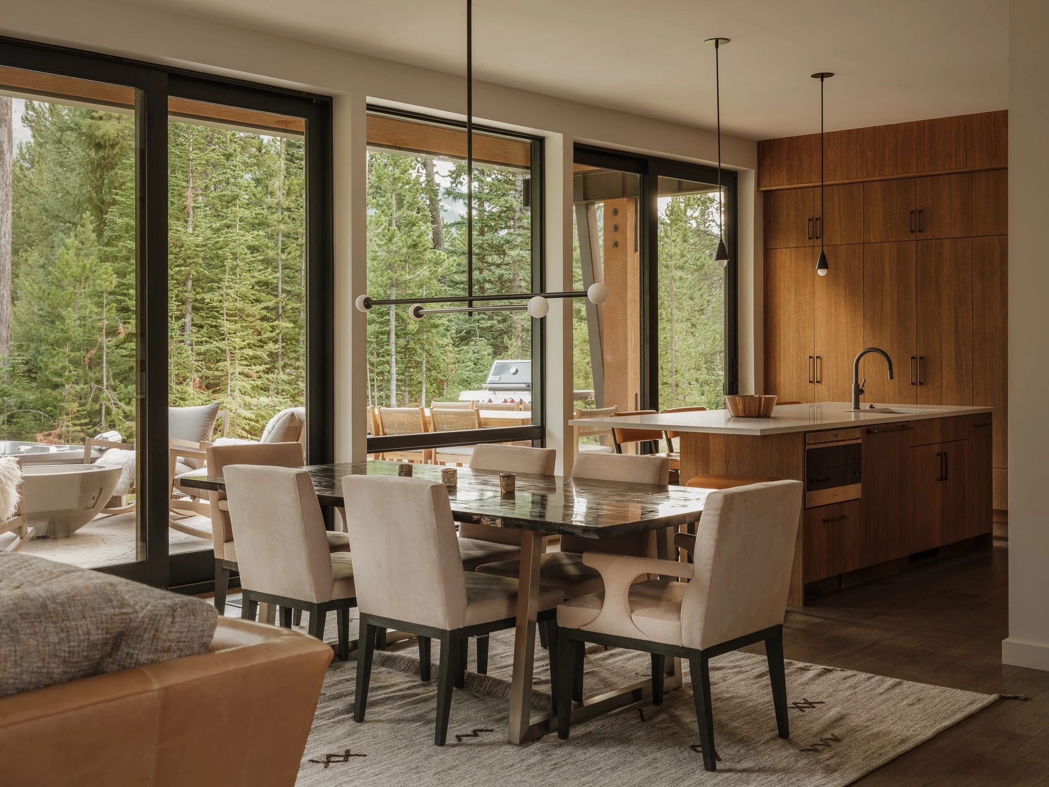 Dining table framed by glass walls onto the forest — interior design photography Big Sky Montana, Speedwell Cabin
